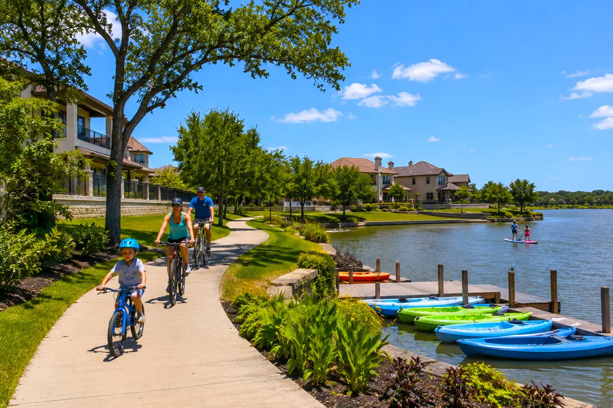 Families biking and kayaking in a Cypress, TX master-planned lakefront community