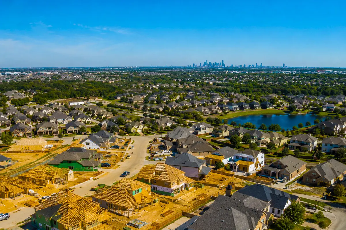 New home construction in Cypress, TX with Houston skyline in the distance, showing rental investment growth