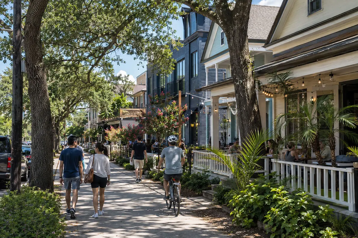 Walkable Houston Proper neighborhood with tree-lined streets, restored homes, cyclists, and local shops in the Heights area