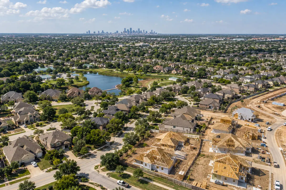 Aerial view of Sugar Land, TX showing established neighborhoods, new home construction, and proximity to Houston, highlighting real estate growth.