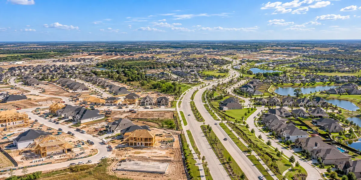 Aerial view of Fulshear, Texas, showing new home construction, established neighborhoods, lakes, and expanding residential development.